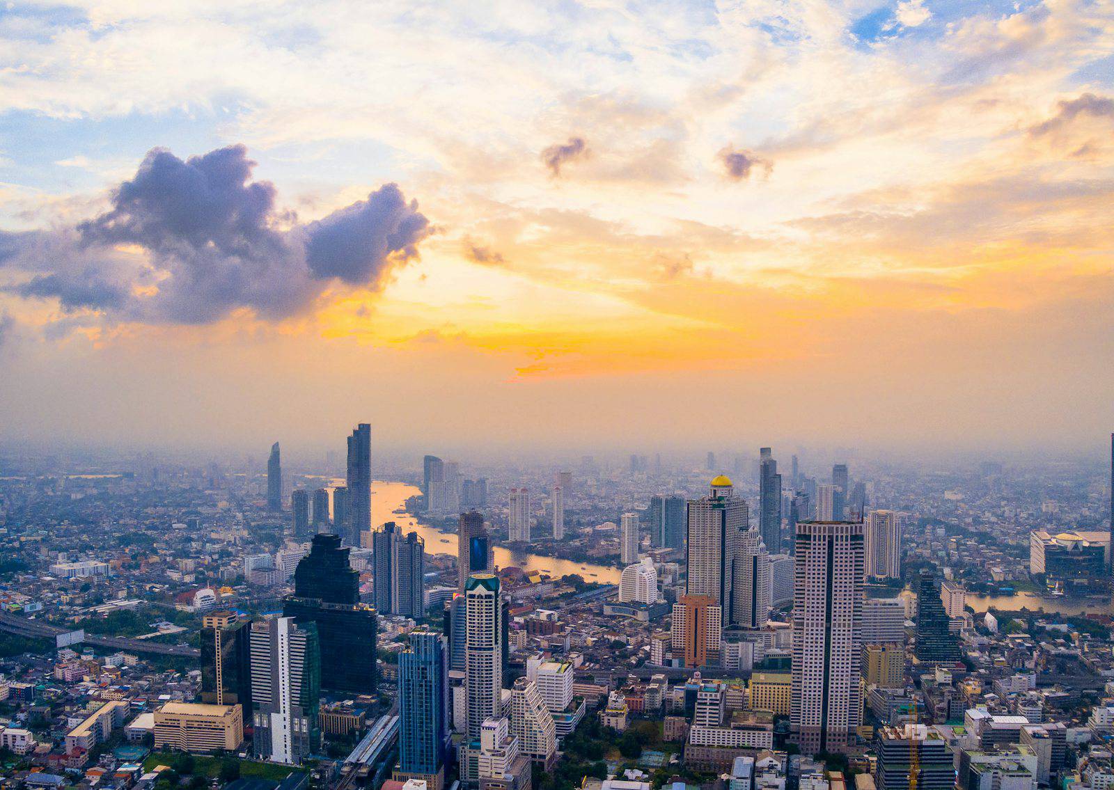 Aerial view of the Bangkok skyline and Chao Phraya River at sunset