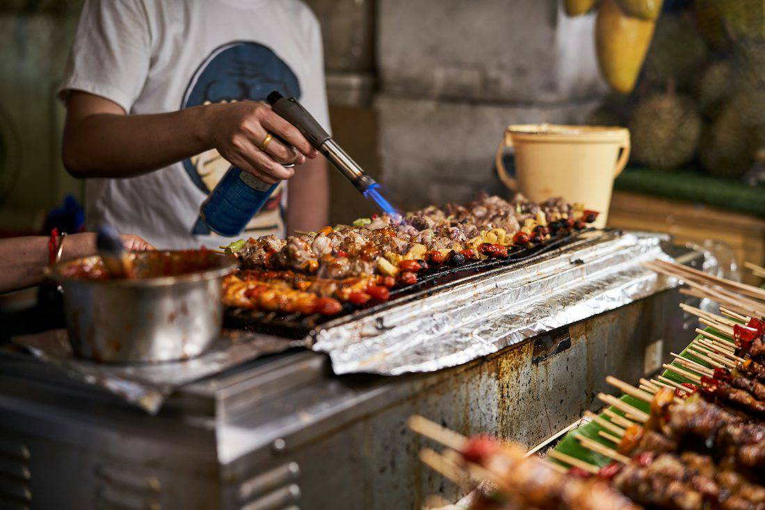 Skewers grilling at a Bangkok street food stall