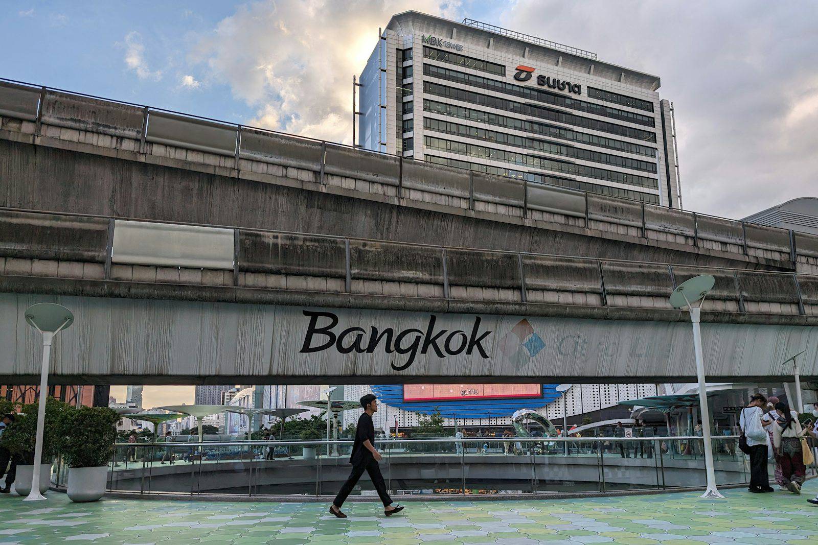 A man walking across a bridge over a river