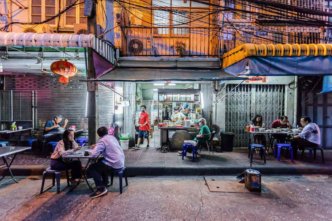 Locals eating at a small shophouse restaurant in Bangkok