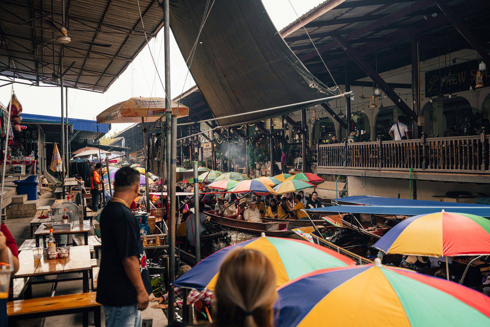 A busy floating market scene with colorful umbrellas.