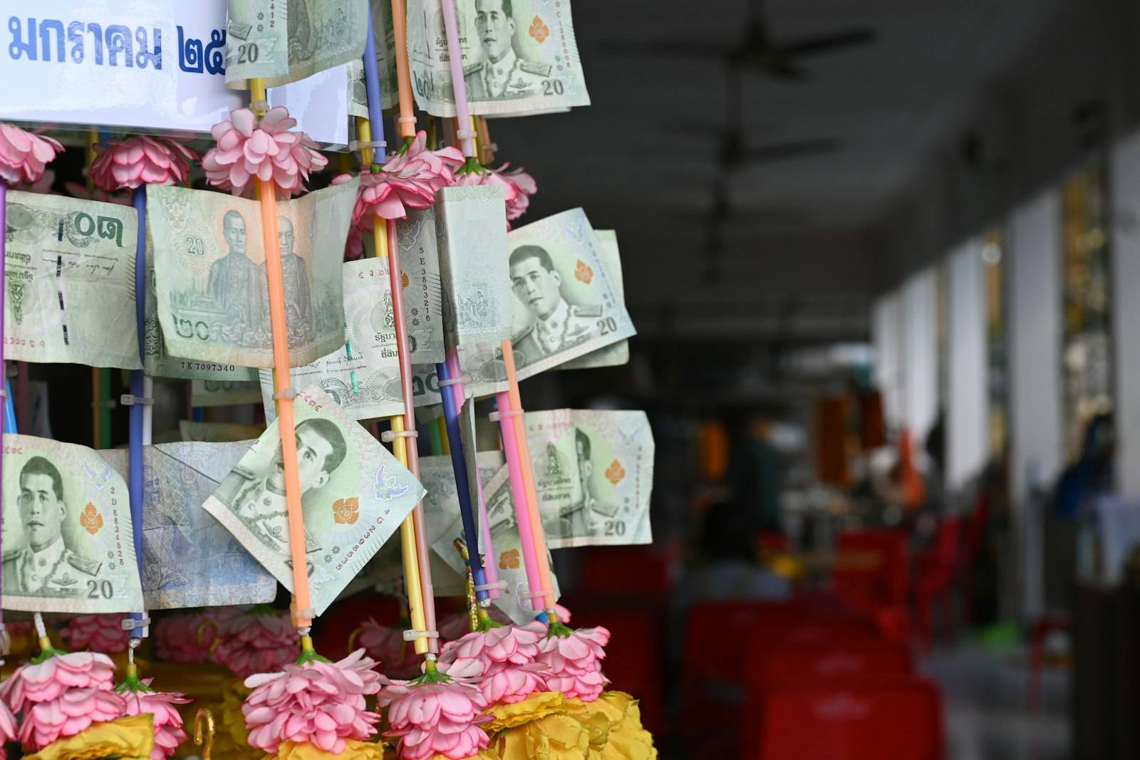 Thai baht banknotes hung as temple offerings