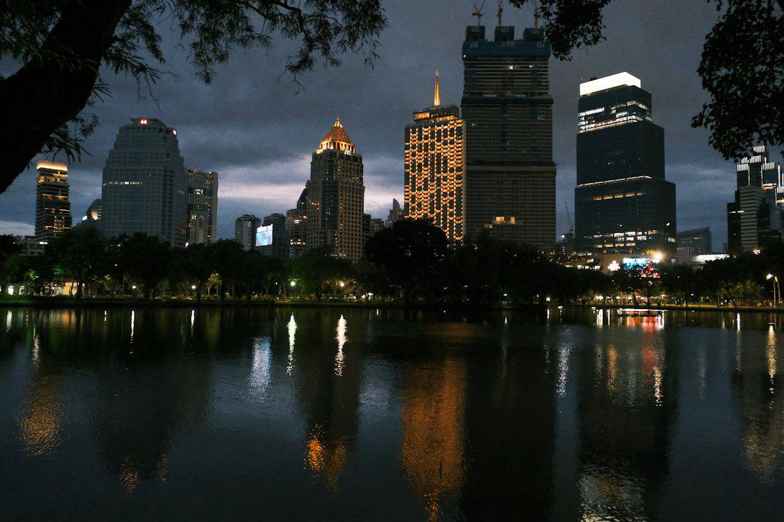 Silom and Sathorn towers reflected in Lumpini Park lake at night
