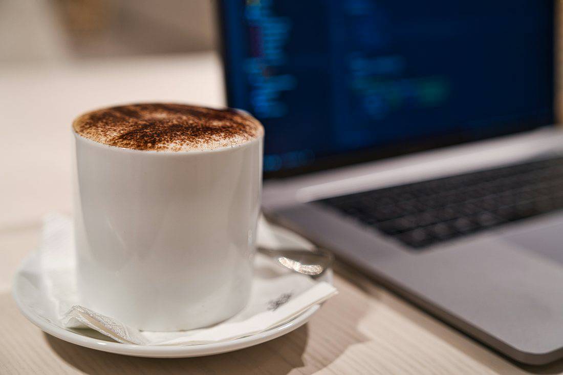 Coffee and laptop setup for a remote work session