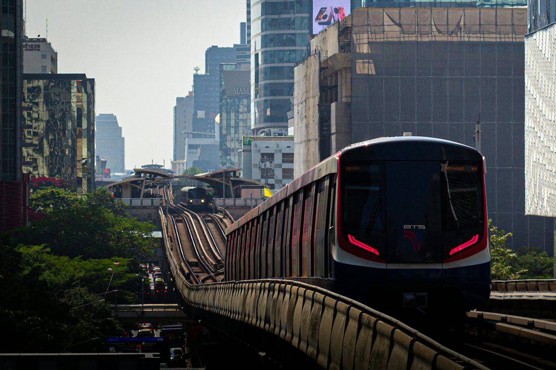 Train heading into central Bangkok between high-rise buildings