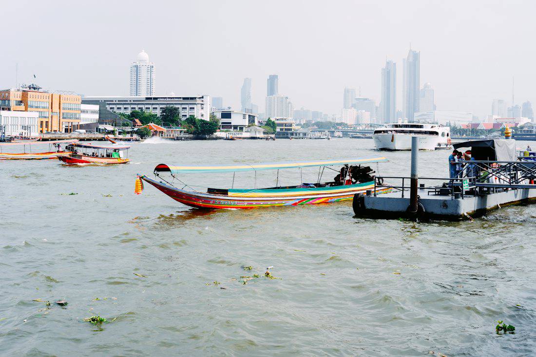 Boats moving along the Chao Phraya River in Bangkok