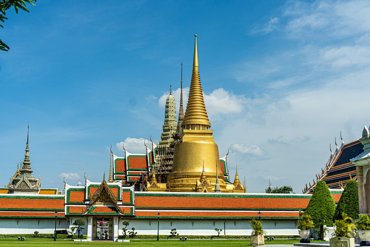 The golden chedi and green-and-orange roofs of Wat Phra Kaew in the Grand Palace grounds
