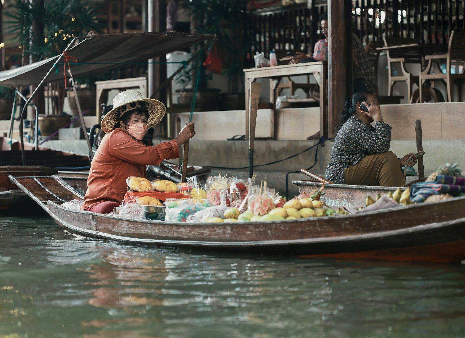 A woman sitting in a boat filled with fruit