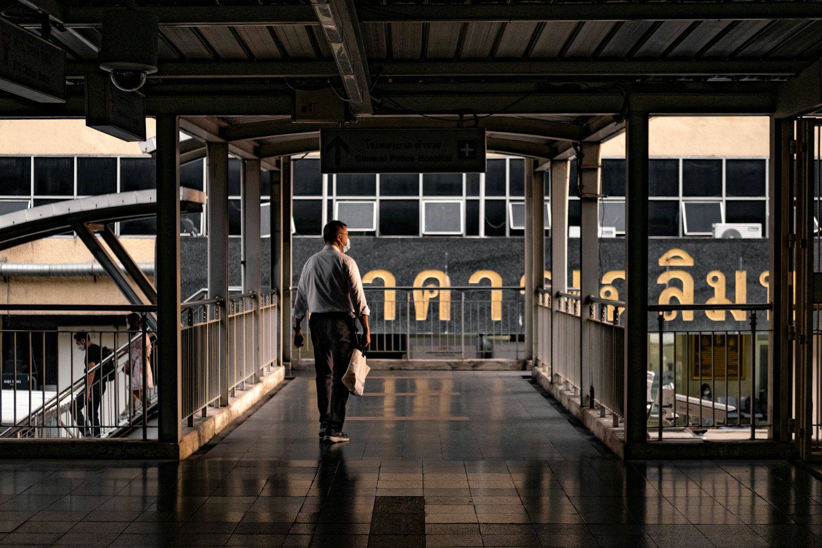 Commuter walking through a covered Bangkok station walkway