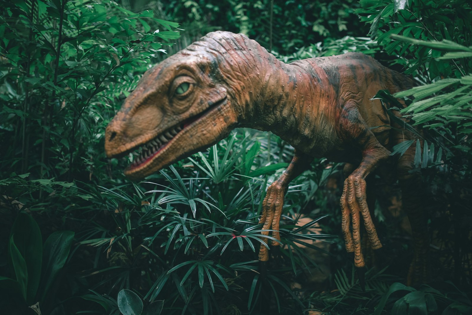 A life-sized animatronic dinosaur in a dim exhibition space