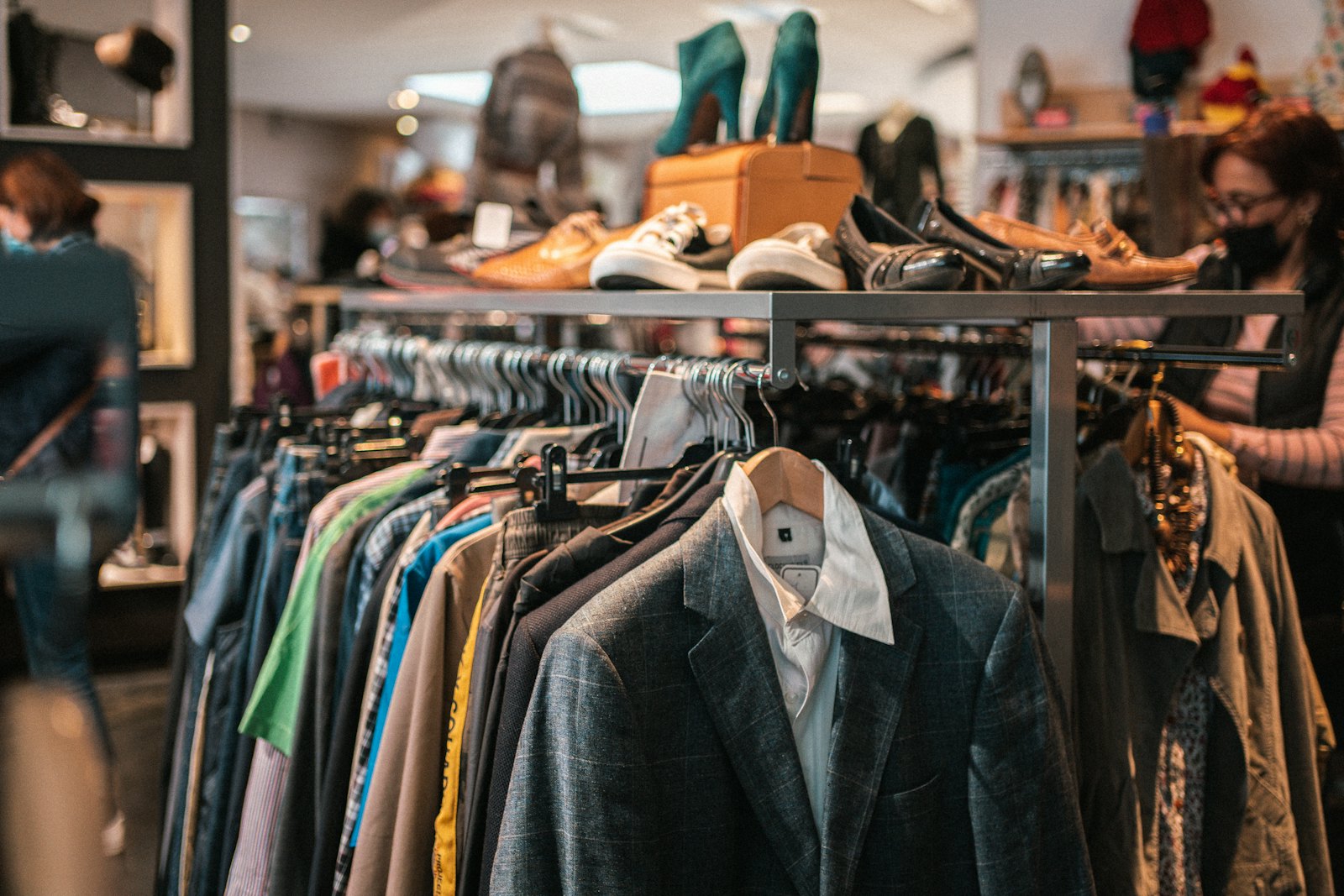 Racks of clothing packed along a narrow market walkway
