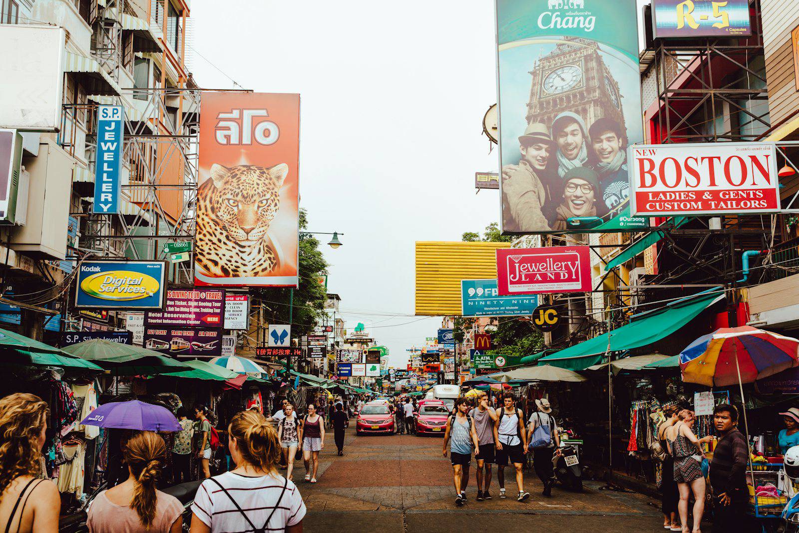 Khao San Road signs and travelers during the day