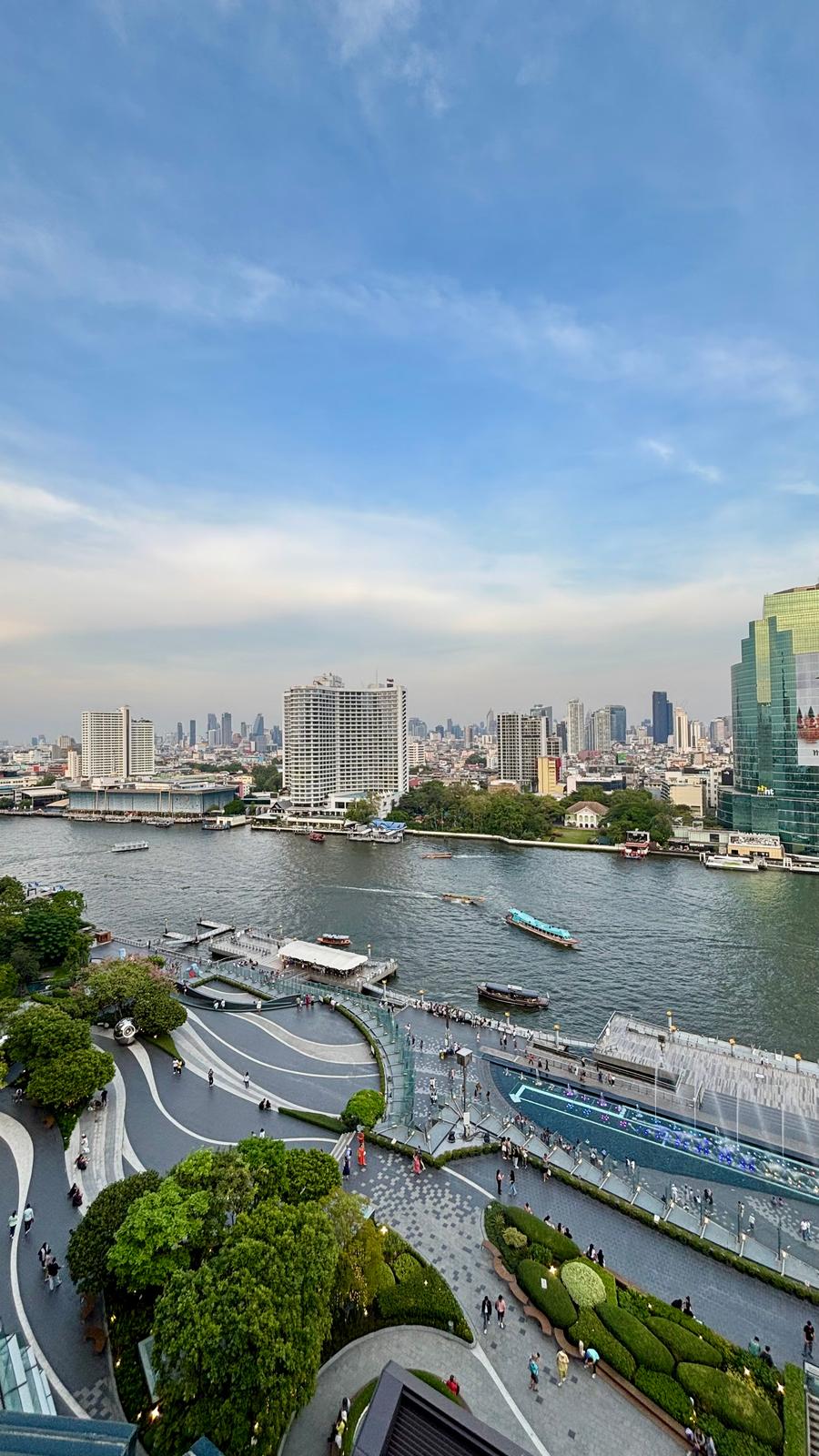 The Chao Phraya River seen from above at ICONSIAM, with boats crossing and the far-bank towers